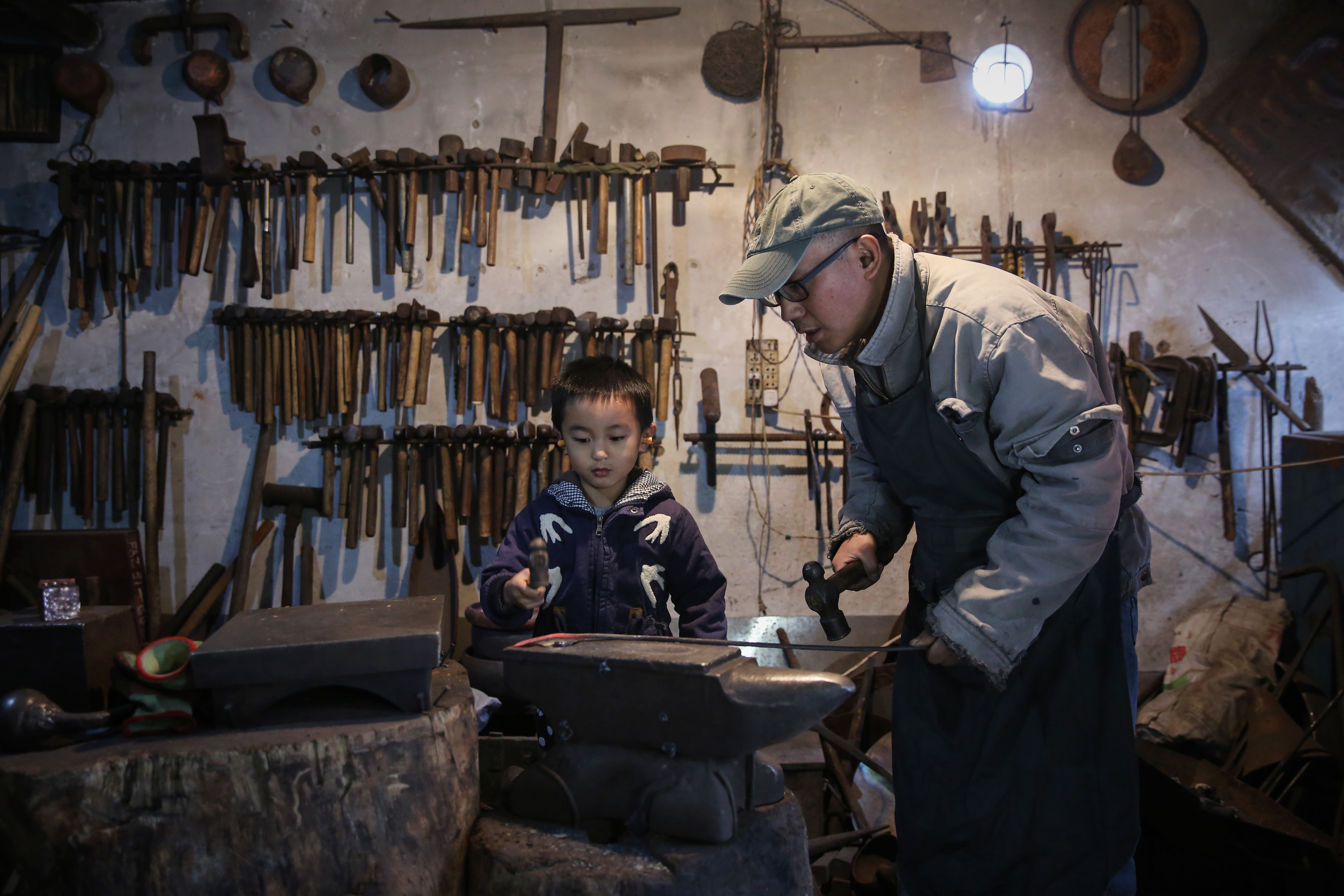 蔡德全的写真-蔡德全教儿子打铁